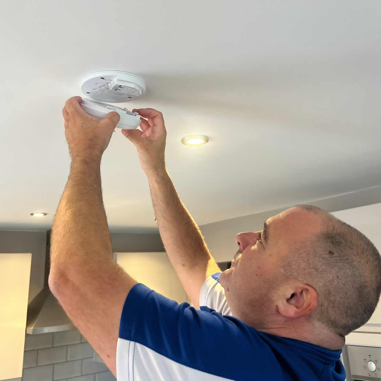 Smoke alarm being installed on a ceiling in Finchley